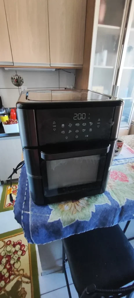 Design da Air Fryer Forno Mondial 12 Litros preta em uma bancada de cozinha, ideal para famílias grandes.