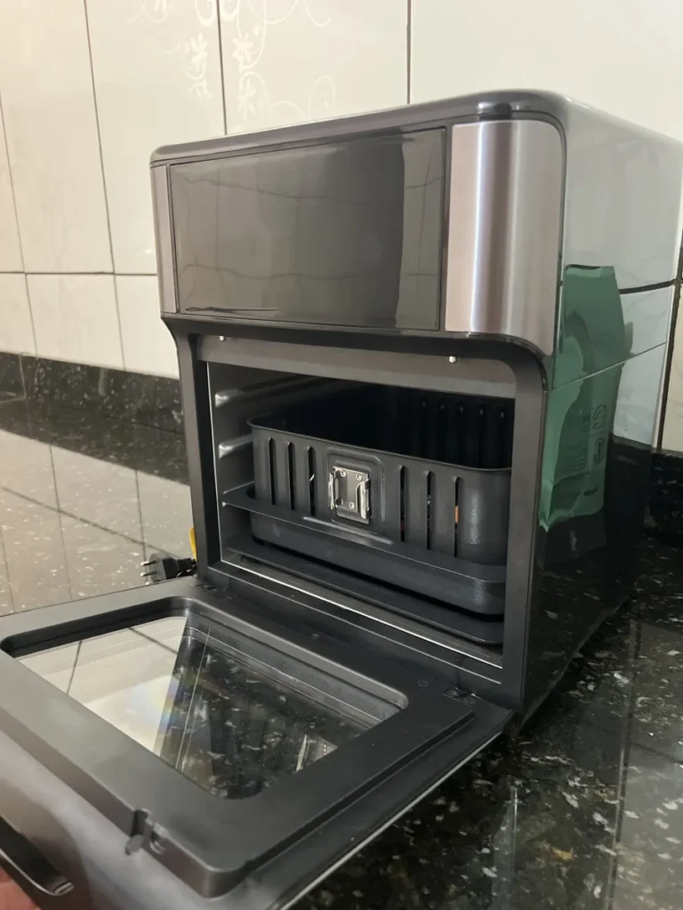 Visão interna da Air Fryer Oven Mondial AFON-12L-BG com porta aberta e cesto removível posicionado.